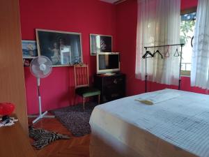 a bedroom with red walls and a bed and a fan at Apartment CENTER CRIKVENICA, SANDY BEACH, 2 bedrooms, in Crikvenica