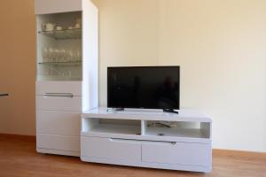 a white entertainment center with a flat screen tv at les Tours de Bombel in Saint-Amand-de-Coly