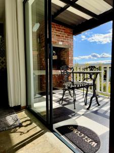 a screened porch with a bench and a fireplace at Salt & Pepper in Mossel Bay