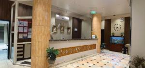 a lobby of a hotel with columns and a bar at كادي للشقق المخدومة in Al Baha