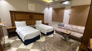 a hotel room with two beds and a couch at كادي للشقق المخدومة in Al Baha +25 photos
