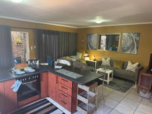 a living room with a kitchen and a living room with a couch at 80onBenade in Bloemfontein