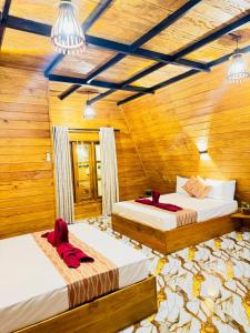two beds in a room with wooden walls at Sigiri Tarushan Home Stay in Sigiriya +84 photos