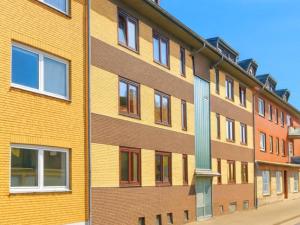 a yellow brick building with windows on a street at L21-Apartment Alsdorf, 2 Zimmer, 3 Betten, Standardisierte Ausstattung, ideal für Reisende, Pendler, Familien in Alsdorf