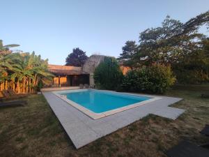 a swimming pool in the yard of a house at Au petit grain in Coutures