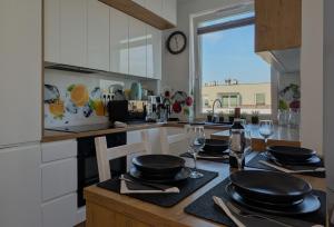 a kitchen with a table with plates and wine glasses at Apartament Białołęka in Warsaw