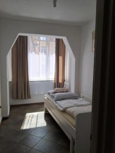 a bed in a room with a window at Historic Tow Center Apartment in Bolesławiec