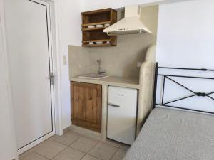 a small kitchen with a sink and a refrigerator at Studios Maniati in Elafonisos