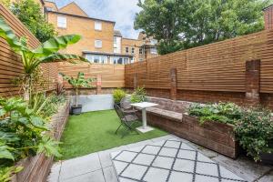 a small garden with a wooden fence and a table at Old Barrel Store - Old Town. Parking & Garden in Margate