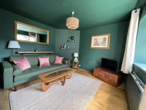 a living room with a green couch and a coffee table at An Teach Ban, homely townhouse in Dungarvan