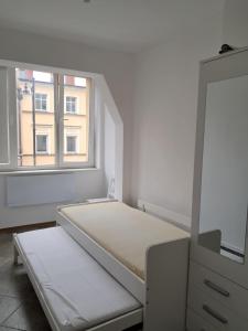 a white room with a bed and a mirror at Historic Tow Center Apartment in Bolesławiec +21 photos