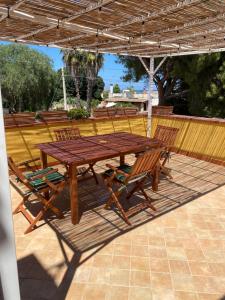 a wooden table and chairs under an umbrella at Casita Lopez Holiday House in Carrozziere