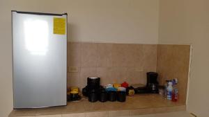 a counter with cups and bottles on a tile wall at Entire house near the city of David in Los Algarrobos