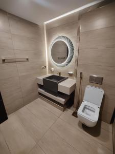a bathroom with a sink and a mirror and a toilet at GoldCrest Mall Luxury Apartments with Balcony In DHA Lahore in Lahore