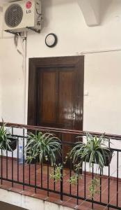 a balcony with a wooden door and two plants at M&O Belgrade in Belgrade