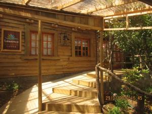 a wooden cabin with stairs in front of it at Hotel Lawenco in Purén