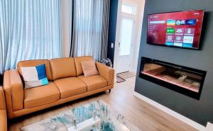 a living room with a couch and a flat screen tv at Brand New 3-Bedroom Home in a Quiet Neighborhood in Calgary