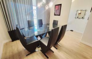 a dining room with a glass table and black chairs at Brand New 3-Bedroom Home in a Quiet Neighborhood in Calgary +30 photos