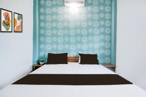 - une chambre avec un lit blanc et un mur bleu dans l'établissement Hotel O Mahamaya Guest House, à Varanasi 21 autres photos