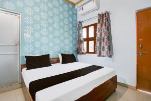 a bedroom with a large white bed in a room at Hotel O Mahamaya Guest House in Varanasi