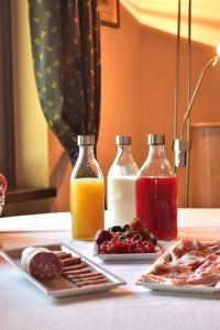 a table with two bottles of juice and a plate of food at tra Arte e Querce in Monchiero