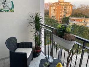 a balcony with a chair and potted plants on it at Airport Flower Home in Marina Julia
