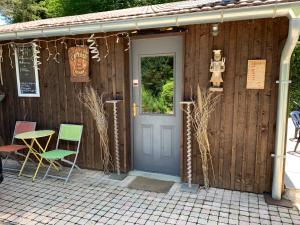 un bâtiment avec une porte, des chaises et une table dans l'établissement le loft de l'Atelier, à Nans-sous-Sainte-Anne