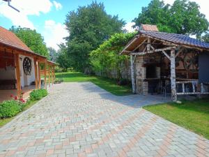 a brick driveway next to a building with a pavilion at Casa de vacanta Marian in Sâmbăta de Sus