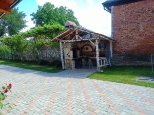a brick patio with a gazebo in a yard at Casa de vacanta Marian in Sâmbăta de Sus +2 photos