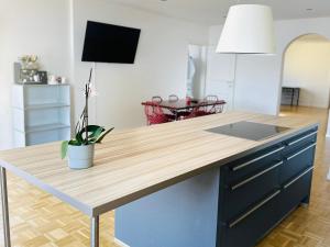 a kitchen with a wooden counter top and a table at Exklusives Apartment mit traumhaftem Seeblick & Balkon in Rorschach