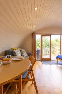 un soggiorno con un tavolo e un divano di Pod3 - Powys River Pods - Pet Friendly Glamping Pod Builth Wells Powys Wales a Garth