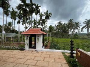 un petit gazebo avec un toit sur un patio dans l'établissement Theeram - Whispers of the River, à Kannur