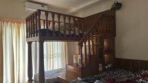 a bedroom with a wooden bunk bed with a staircase at Theeram - Whispers of the River in Kannur