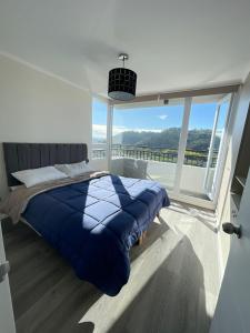 a bedroom with a bed and a large window at Hermoso departamento nuevo en Concepción 3 in Concepción