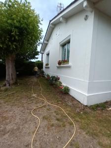 ein Haus mit einem Gartenschlauch neben einem Gebäude in der Unterkunft Maison individuelle avec jardin in Soulac-sur-Mer