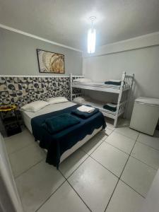 a bedroom with a bed and a desk in it at Hospedagem Doce lar in Joinville