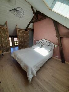a bedroom with a white bed in a attic at Aux Iris in Saint-Léon-sur-Vézère +26 photos