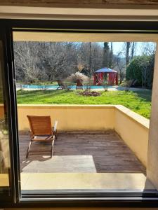 a window view of a patio with a chair at Aux Iris in Saint-Léon-sur-Vézère