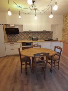 a kitchen with a wooden table and chairs at Aux Iris in Saint-Léon-sur-Vézère