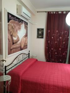 a bedroom with a red bed with a large poster at Scilla Beach in Scilla