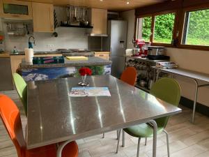 une cuisine avec une table et des chaises en acier inoxydable dans l'établissement le loft de l'Atelier, à Nans-sous-Sainte-Anne