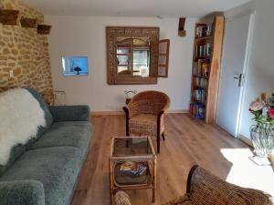 a living room with a couch and a table at Aux Iris in Saint-Léon-sur-Vézère