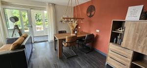 a living room with a table and a couch at De tepelenburg in Harskamp