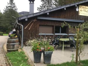 une cabane avec une table, des chaises et des fleurs devant dans l'établissement le loft de l'Atelier, à Nans-sous-Sainte-Anne