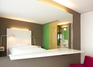 a bedroom with a bed and a mirror at Hotel Restaurant Rössli in Bad Ragaz