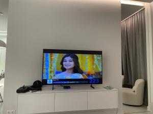 a flat screen tv sitting on top of a white cabinet at Bamboo Tsikhisdziri Apartment in K'obulet'i