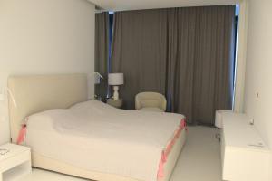 a bedroom with a bed and a chair and a window at Bamboo Tsikhisdziri Apartment in K'obulet'i +12 photos