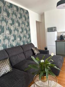 a living room with a couch and a table at Le Parfait in Beauvais +15 photos