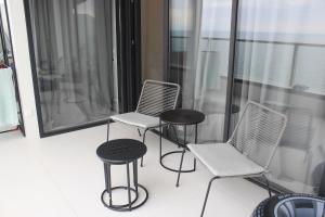 two chairs and two stools on a balcony at Bamboo Tsikhisdziri Apartment in K'obulet'i