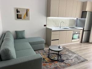 a living room with a couch and a kitchen at Rei's Apartment 2 in Tirana